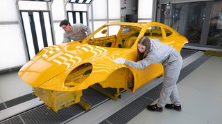 Mitarbeiter der Porsche AG prüfen im Fahrzeugaudit der Lackiererei im Stammwerk in Zuffenhausen eine Karrosserie. Ein zweites Sparpaket soll bei Porsche den Abbau von bis zu 4.000 weiteren Stellen vorsehen, berichtet das Handelsblatt.