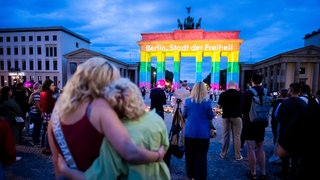 Das Brandenburger Tor wird in Regenbogenfarben illuminiert, wobei der Schriftzug "Berlin, Stadt der Freiheit" zu lesen ist. Der Christopher Street Day in Berlin war am Vortag abgebrochen worden, nachdem ein Auto am Rande der Großveranstaltung in eine Menschenmenge gefahren war. 
