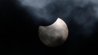 Der Mond verdeckt Teile der Sonne. Eine partielle Sonnenfinsternis ist zu sehen.