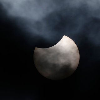 Der Mond verdeckt Teile der Sonne. Eine partielle Sonnenfinsternis ist zu sehen.