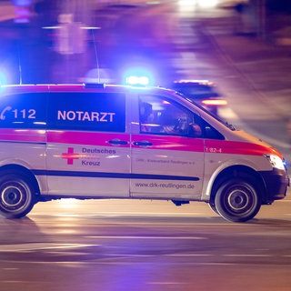 Ein Notarztwagen des Deutschen Roten Kreuz auf Einsatzfahrt mit aktiviertem Blaulicht