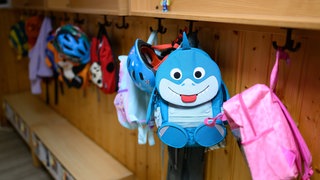 Kinderrucksäcke hängen in der Garderobe einer Kita.