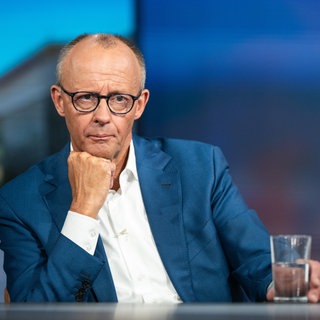 Bundeskanzler Friedrich Merz (CDU) sitzt an einem Tisch.
