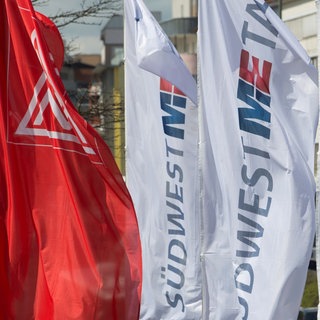 Flaggen von Südwestmetall und der IG Metall wehen im Wind.