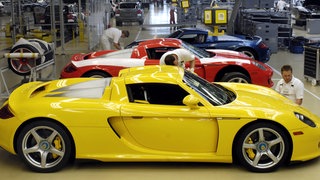 In einem Werk des Sportwagenherstellers Porsche arbeiten Monteure an einem Sportwagen Carrera GT. Porsche hat seine neue Strategie vorgestellt und will künftig mehr auf Sportwagen setzen.