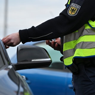 Ein Bundespolizist kontrolliert ein Auto an der Grenze zwischen Frankreich und Deutschland.