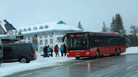 Ein Bus hält am verschneiten Caritashaus am Feldberg