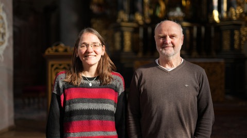 Zwei Gläubige stehen in der Kirche