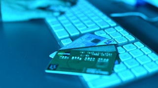 Eine Computertastatur auf der Kreditkarten liegen. 