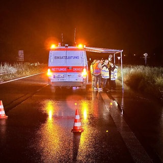 Einsatzkräfte und das Kriseninterventionsteam stehen an einer abgesperrten Straße in Freiburg nach einem Unfall mit mehreren Toten.