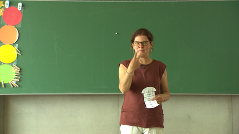 Eine Lehrerin an der Tafel in einer Grundschulklasse