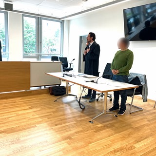 Der Angeklagte steht im Landgericht Freiburg an seinem Platz. Neben ihm sein Verteidiger.