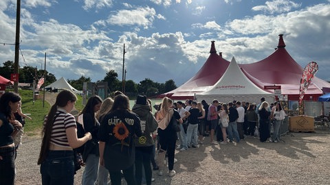 Viele junge Menschen stehen Schlange vor dem Zirkuszelt beim ZMF, um das Konzert von Künstler GReeeN zu sehen. 