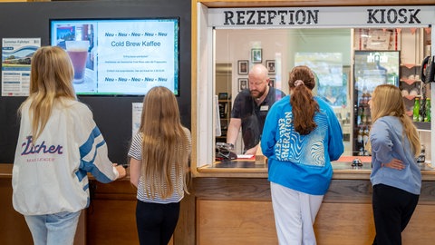 Menschen stehen an der Rezeption