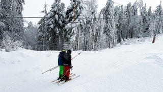 Zwei Skifahrer in einem Schlepplift im Schwarzwald.