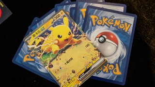 Mehrere Pokémon-Karten liegen auf dem Tisch. 