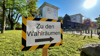 Schild mit der Aufschrift: Zu den Wahlräumen