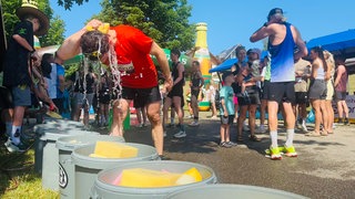 Sport bei Hitze: Ein Mann kühlt sich den Kopf mit Wasser
