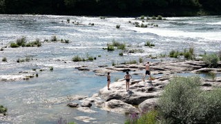 Drei Badende an den Isteiner Schwellen am Altrhein bei Efringen-Kirchen. Obwohl baden verboten ist, wird der Rhein hier an heißen Tagen zum öffentlichen Freibad. 