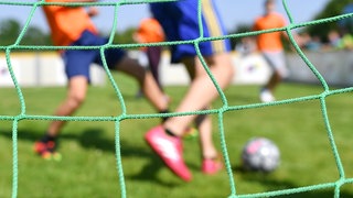 Kinder spielen auf einem Fußballplatz (Symbolbild)