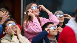 Schaulustige beobachten eine Sonnenfinsternis