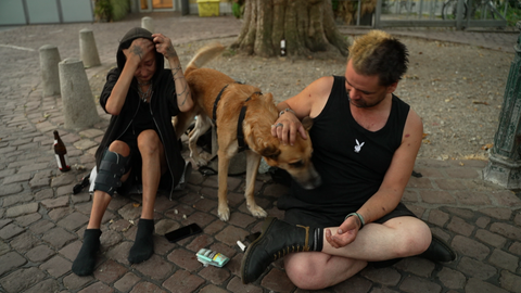 "Eimer" schützt sich und seinen Hund unter einem Baum vor der brennenden Sonne. 