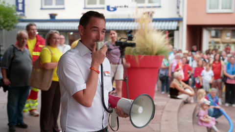 Alexander Schropp von der DLRG spricht beim Protest in Neuenburg in ein Megafon. 