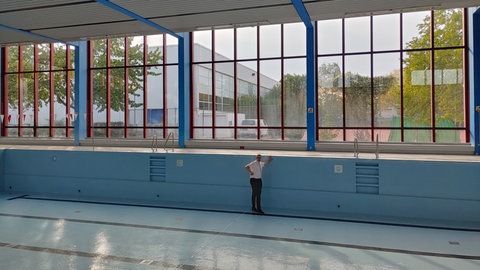 Der Neuenburger Bürgermeister steht im leeren Schwimmbecken. 