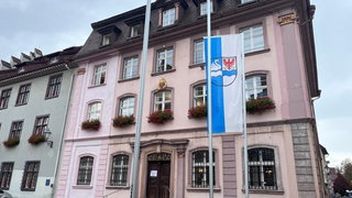 Blick aufs Rathaus Villingen-Schwenningen. Im Vordergrund ist die Stadtfahne gehisst.