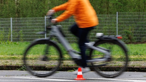 Eine Radfahrerin fährt mit ihrem Pedelec über einen Verkehrsübungsplatz. Beim Fahrsicherheitstraining lernen Fahrerinnen und Fahrer, wie sie ihr Pedelec richtig händeln.