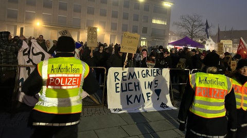 Demonstranten mit Plakaten vor der Stadthalle in Singen.