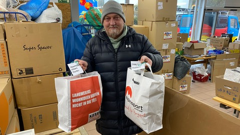 Ralf Eisenhut mit zwei Papiertaschen in der Hand. Er sammelt auch Kleidung für die Ukraine. 