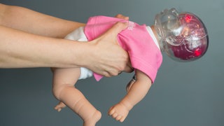 Eine Schüttelpuppe wird geschüttelt. 