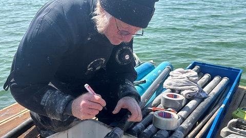 Ein Wissenschaftler untersucht Bohrkerne, die aus dem Grund des Bodensee vor Unteruhldingen entnommen wurden. 