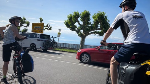 Radler kreuzen die Bundesstraße in Meersburg. Immer mehr Radfahrer sind auf dem Bodensee-Radweg unterwegs.