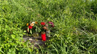 Kerzen und Blumen standen auf dem Ufergrundstück in Nonnenhorn, auf dem die Leiche der 70-Jährigen gefunden wurde. (Archivbild)