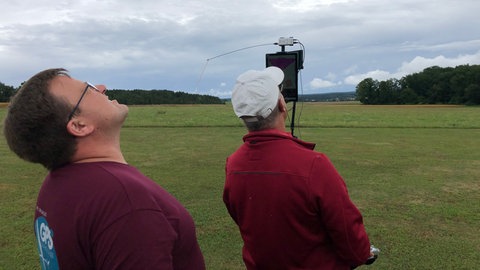 Teamarbeit bei der Weltmeisterschaft in Heudorf: Wenn ein Modell-Flugzeug in der Luft fliegt, schaut ein Teammitglied ihm nach, ein anderer kontrolliert auf dem Tablet die Flugroute.