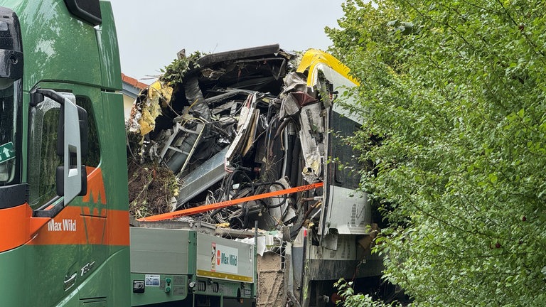 Bergung der entgleisten Zugteile. Die Waggons des entgleisten Regionalexpresses werden von den Gleisen gehoben und auf Tieflader gesetzt.