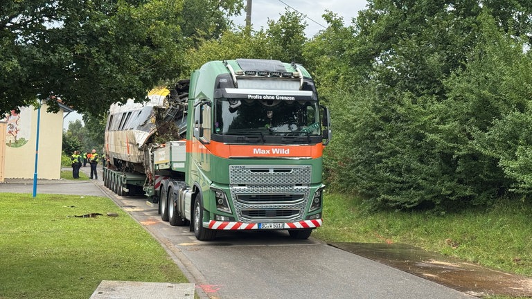 Bergung der entgleisten Zugteile. Die Waggons des entgleisten Regionalexpresses werden von den Gleisen gehoben und auf Tieflader gesetzt.