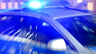 Ein Streifenwagen der Polizei steht mit eingeschaltetem Blaulicht auf der Straße. (Symbolbild)