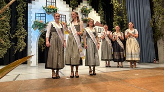 Strahlende Gesichter auf der Bühne beim Hopfenball in Tettnang-Obereisenbach. Dort sind die neue Hopfenkönigin und zwei Prinzessinnen gewählt worden. Sie haben durch Schlagfertigkeit, Fachwissen, Kreativität und Charme geglänzt.