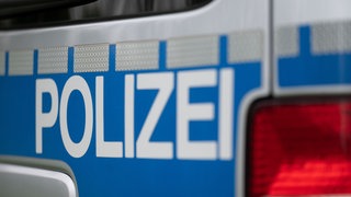 Das Wort Polizei ist auf einem Fahrzeug der Polizei zu sehen. Nach Mord vor 40 Jahren hat die Polizei in Schwendi im Kreis Biberach das Haus und das Grundstück eines Tatverdächtigen durchsucht.