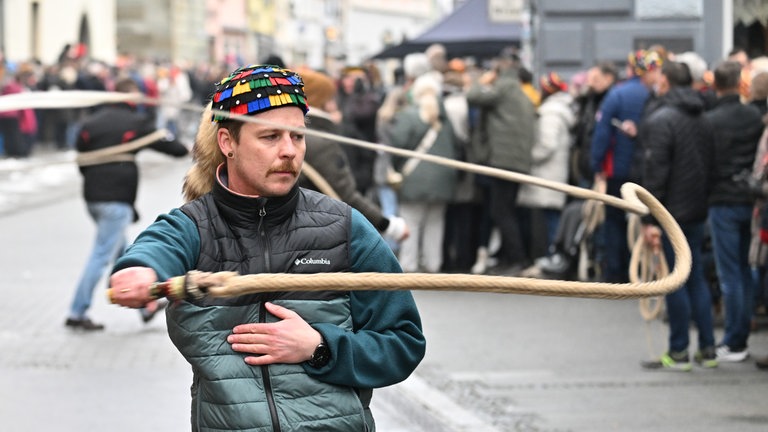 Daniel Sinner, Narr der Hänselezunft Überlingen (HZÜ), schnellt wie Dutzende anderer Narren mit Karbatschen vor dem Münster die Fastnacht ein. (Archivbild)
