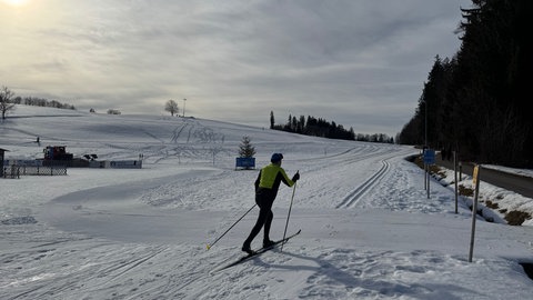 Ein Langläufer nutzt das schöne Wetter in Isny zum Langlaufen.