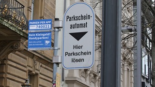 Ein Schild, das auf einen Parkscheinautomat hiweist. Auf dem kleinen Schild daneben steht: Kein Kleingeld? Handyparken! In Konstanz warnt die Stadt vor Betrügern an Parkautomaten (Symbolbild).