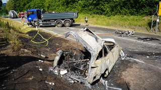 Eine Unfallstelle auf der B30 bei Meckenbeuren (Bodenseekreis). Das Auto brannte nach dem Frontalzusammenstoß komplett aus. 