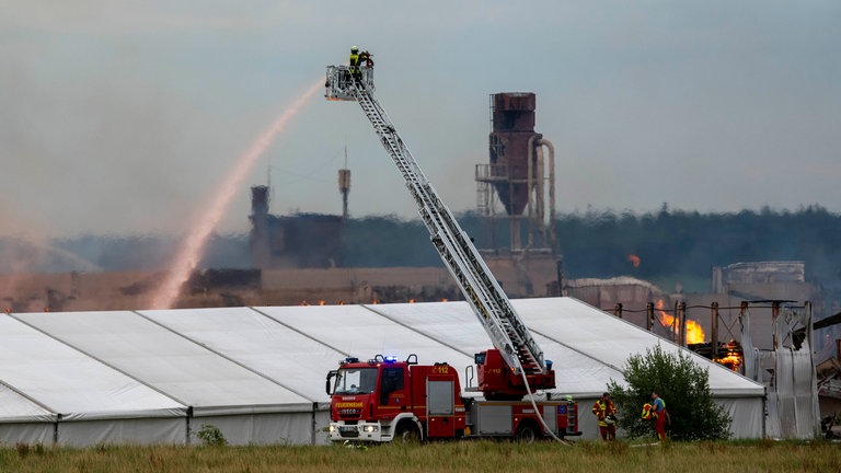 Mit einer Drehleiter löscht die Feuerwehr den Brand in einem holzverarbeitenden Betrieb