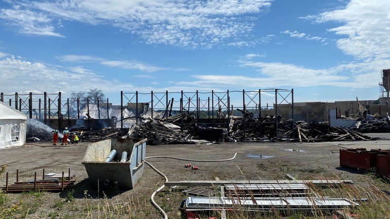 In den Ruinen der Holzbaufirma in Eberhardzell löscht die Feuerwehr am Freitag weiter