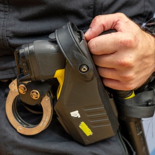 Ein Polizist hält Handschellen in der Hand. In Venezuela hat die Polizei einen Mann festgenommen, der in Owingen seine Mutter wochenlang in den Keller gesperrt haben soll.