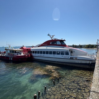 Eine Katamaran-Fähre steht am Hafen in Konstanz an einer Kaimauer. 